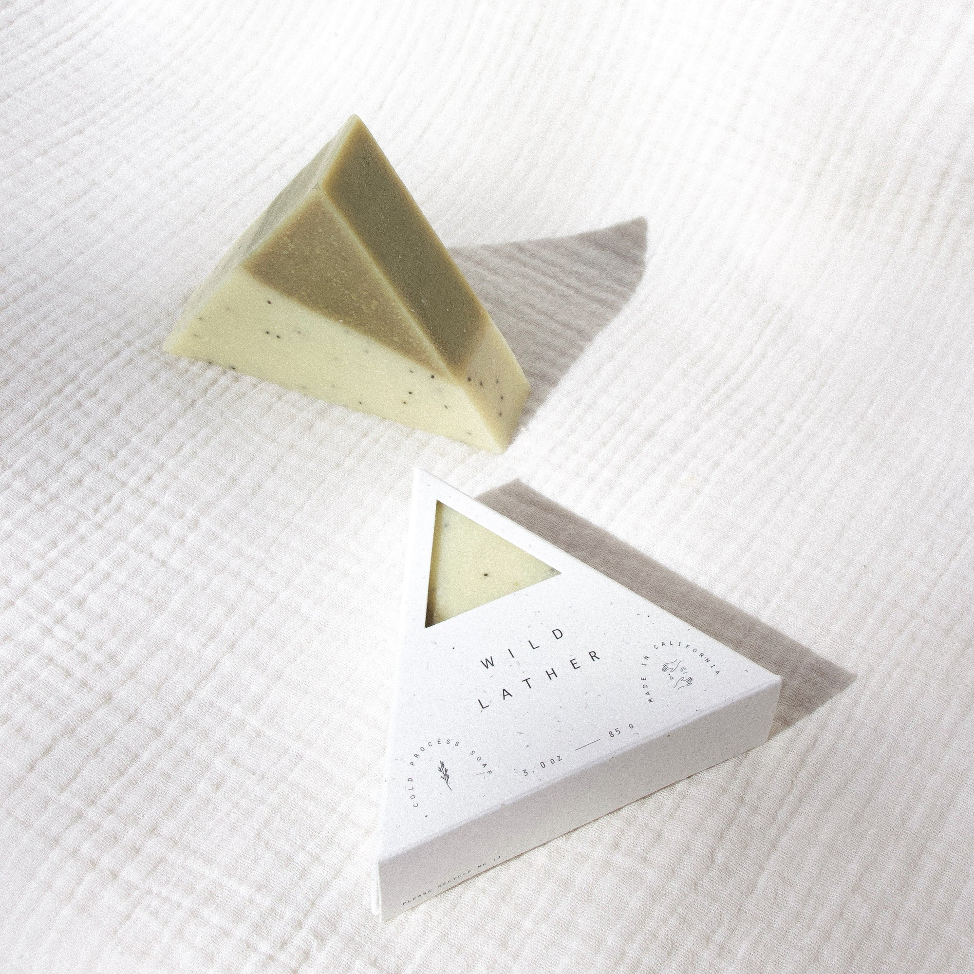 Two triangle soaps against white textured cloth