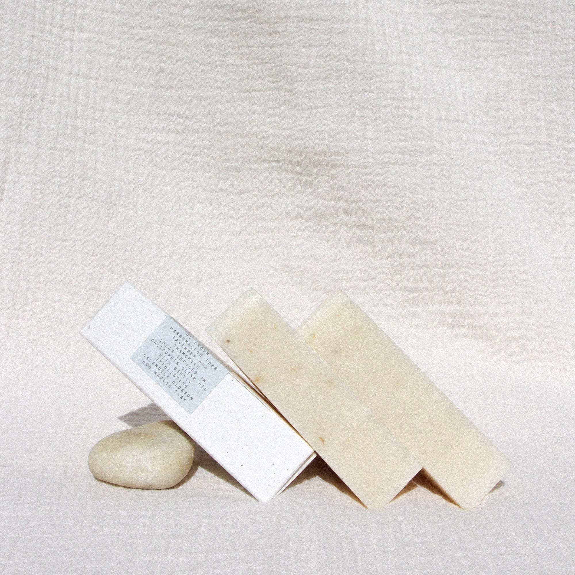 Three triangle soaps leaning against a stone
