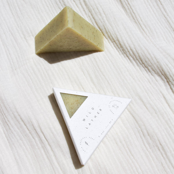 A packaged and unpackaged triangle soap next to one another