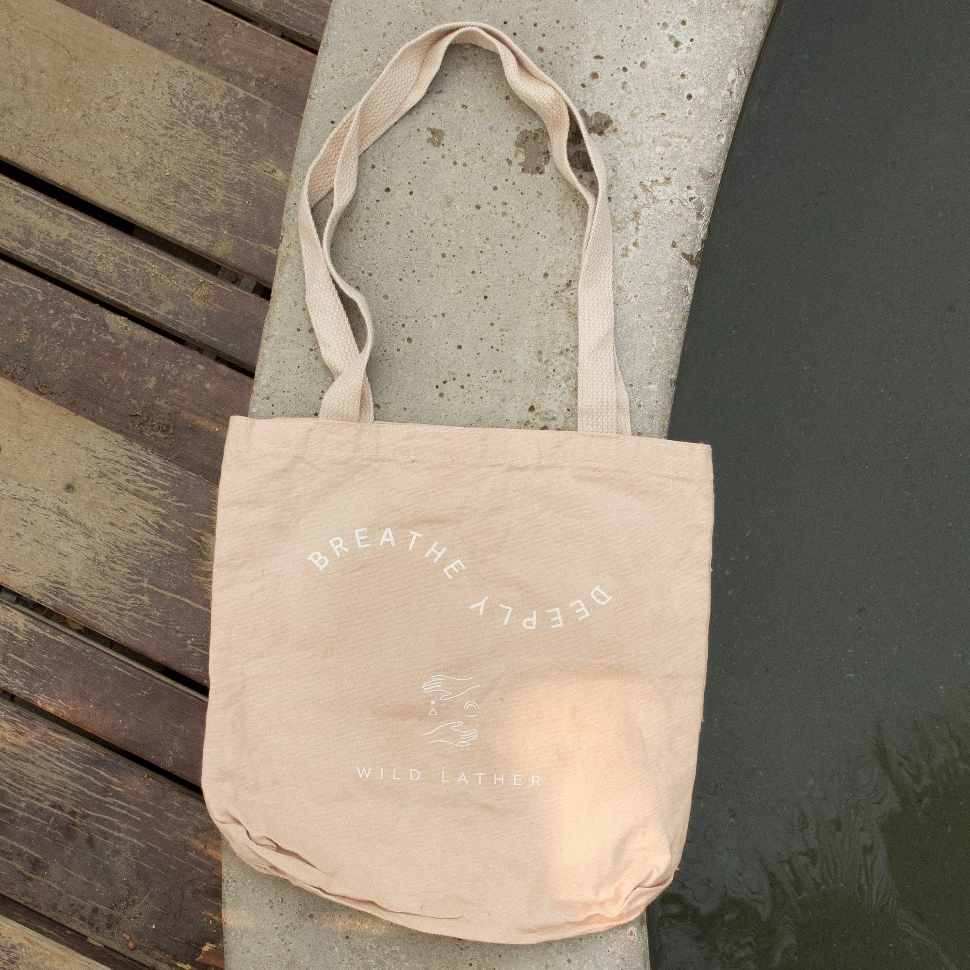 A pale blush tote on the edge of a hot spring tub
