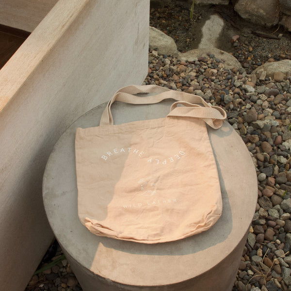 A pale blush tote next to a cedar hot tub