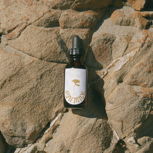 A bottle of Sun Milk Oil on a rock in the sun