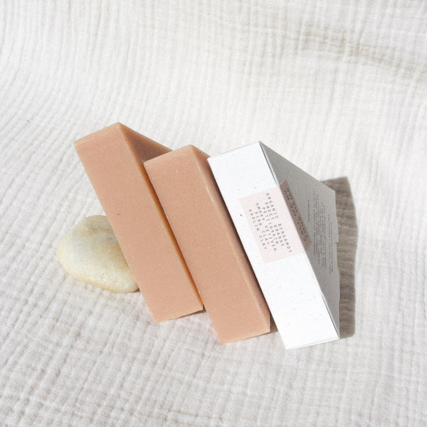 Pink clay soap packaged in a speckled white triangle box