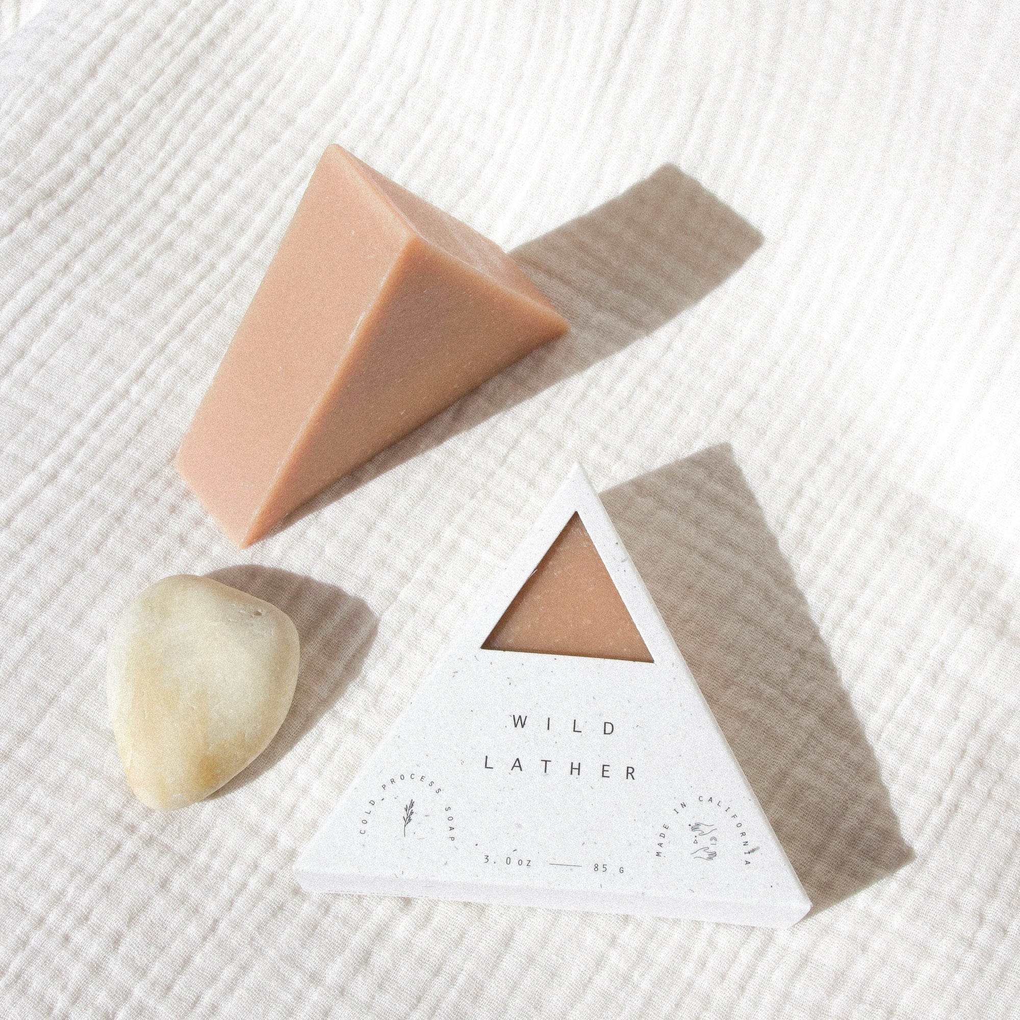 Pink clay soap packaged in a speckled white triangle box