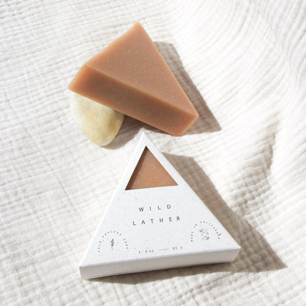 Pink clay soap packaged in a speckled white triangle box