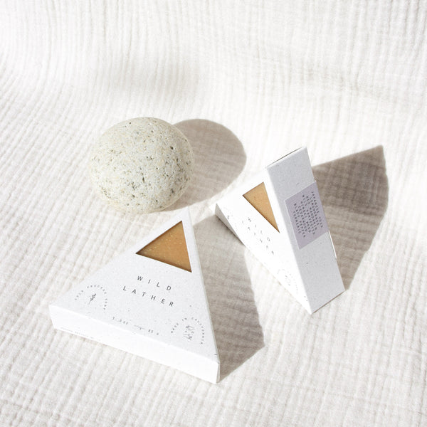 Turmeric colored triangle soap packaged in a speckled white triangle box