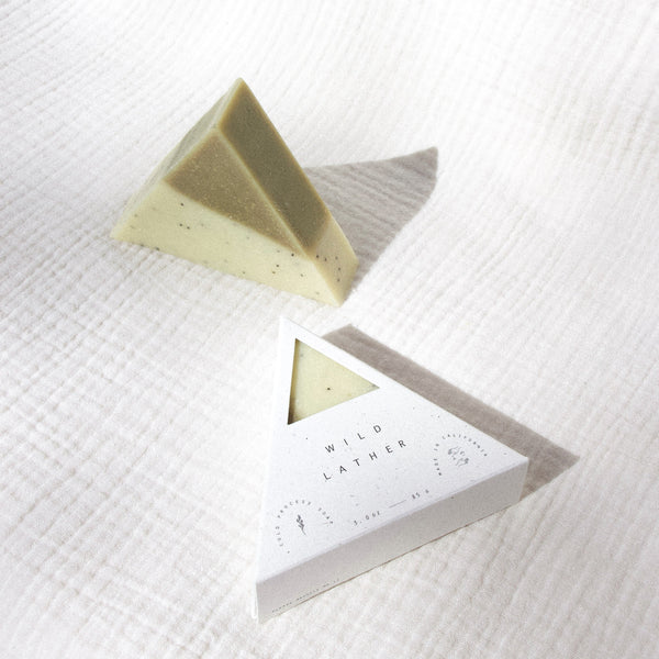 Two triangle soaps against white textured cloth