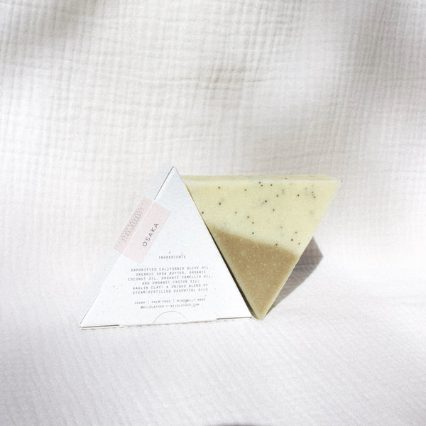 Two triangle soaps against white textured cloth