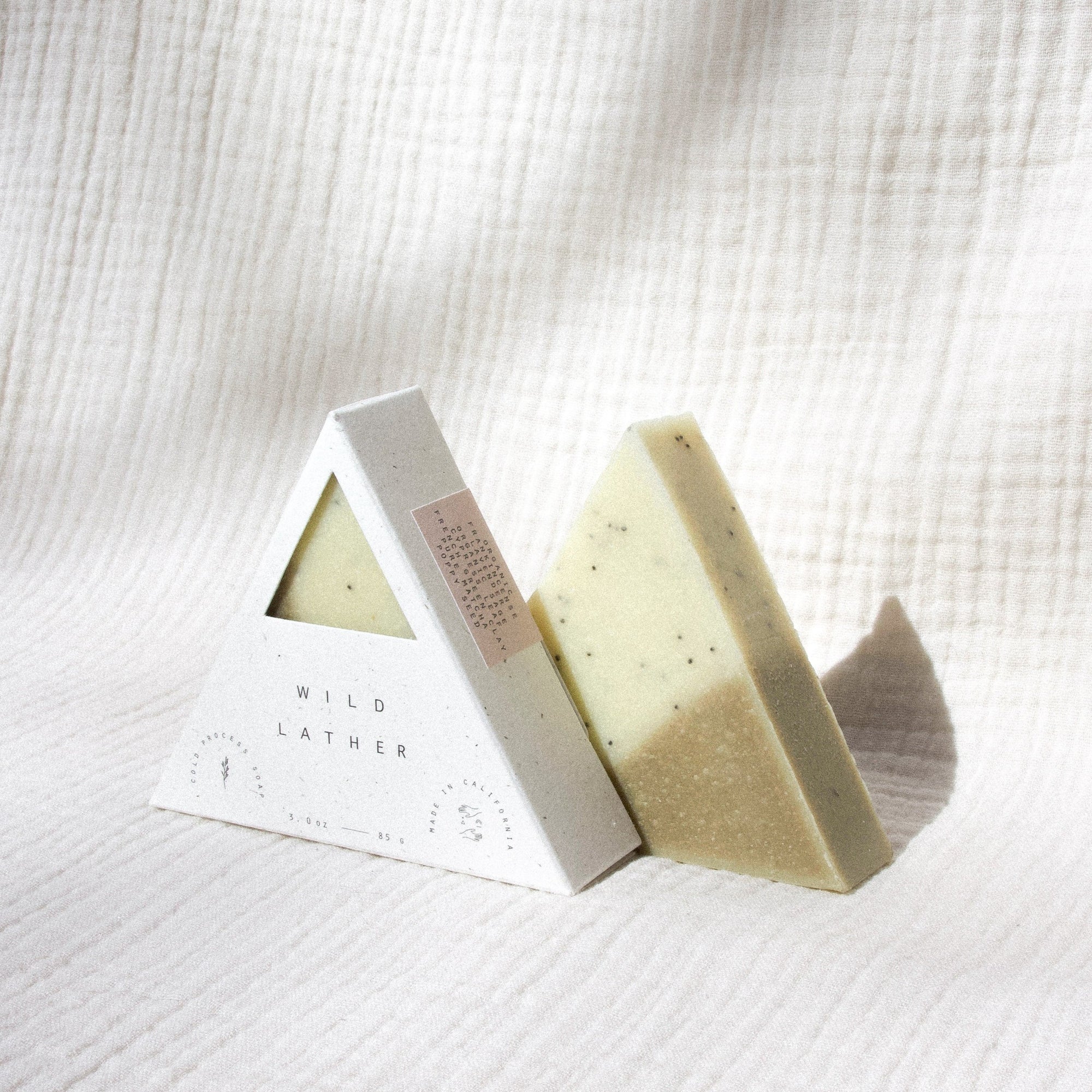 Two triangle soaps against white textured cloth