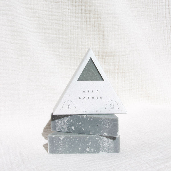 Three triangle soaps stacked on top of each other against textured linen